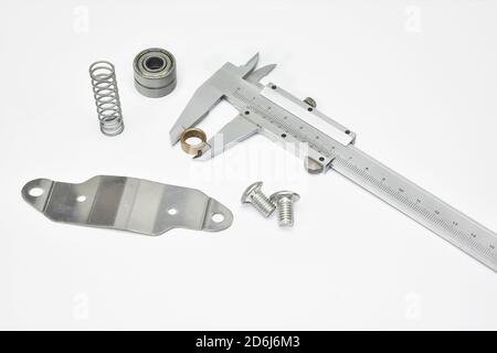 Mesure des matériaux techniques avec pied à coulisse.pied à coulisse,ressort et palier métalliques composition d'arrière-plan de l'industrie du métal blanc isolé par balle Banque D'Images