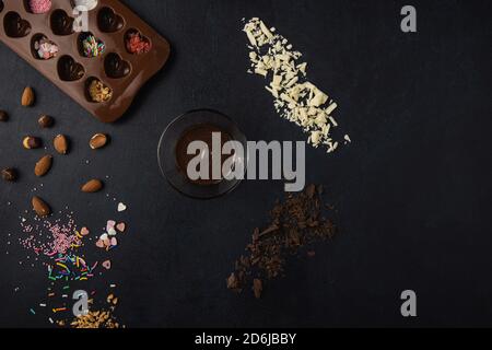 Ingrédients de pralines de chocolat isolés sur un fond sombre. Vue de dessus, plan d'appartement. Banque D'Images