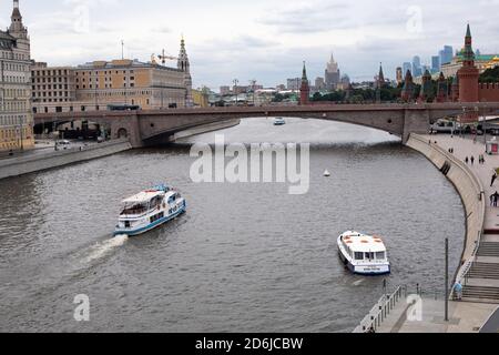 Moscou, Russie - 24 août 2020 : pont Bolchoï Moskvoretsky et remblai du Kremlin. Bateau touristique naviguant le long de la rivière Moskva contre le bac Banque D'Images