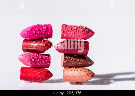 rouges à lèvres humides et colorés sur fond blanc Banque D'Images