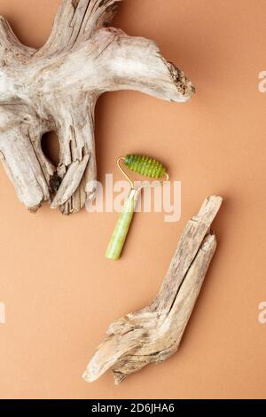 Concept de beauté moderne et luxueux - Kit de massage facial et racine en bois sur fond de papier beige. Rouleau de massage pour le visage et masseur pour guasha Banque D'Images