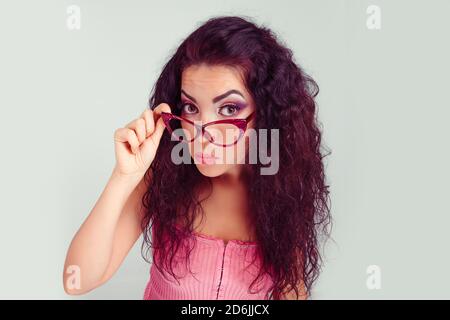 Tête de feu grave en colère bitchy femme tenant des lunettes de soleil bas en regardant avec scepticisme vous isolé vert clair gris blanc mur arrière-plan. Fac humain Banque D'Images