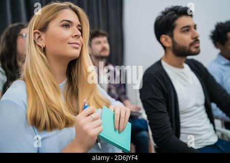 Groupe de personnes d'affaires créatives à l'écoute d'un collègue lors d'une réunion de bureau. Concept d'entreprise et de brainstorming. Banque D'Images