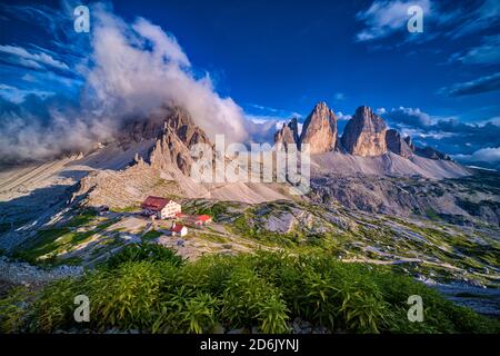 Vue panoramique aérienne sur le groupe de montagnes Tre Cime di Lavaredo, avec la cabane de montagne Dreizinnenhütte, Rifugio Locatelli et une petite chapelle. Banque D'Images