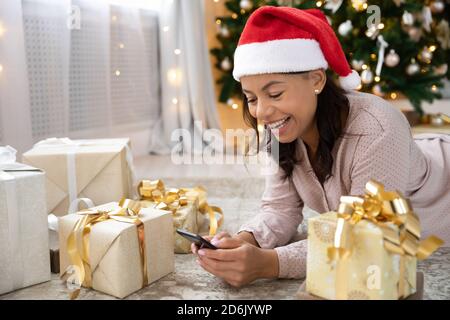 Souriant biracial femme salutation avec des vacances d'hiver sur le téléphone portable Banque D'Images