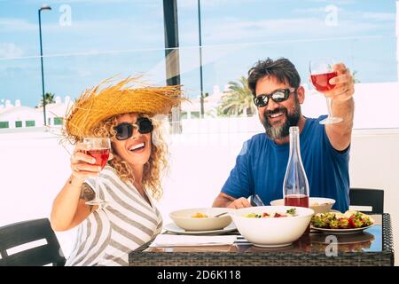 Les gens en vacances et en vacances d'été s'y réunissent en couple - l'homme heureux et la femme adulte adulte adulte profiter du déjeuner et le vin rouge ayant le plaisir et Banque D'Images