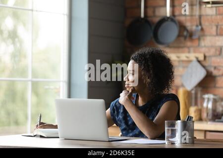 Femme biraciale rêveuse distraite de la pensée informatique Banque D'Images