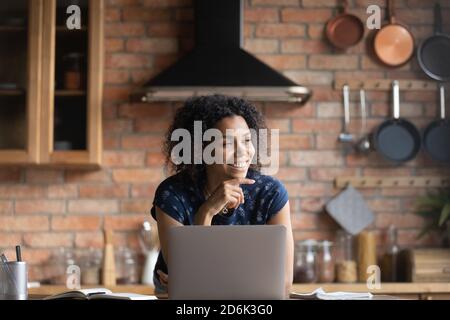 Femme afro-américaine souriante, dram distraite du travail informatique Banque D'Images