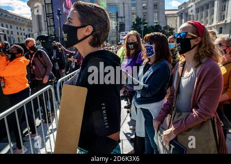 Les manifestants écoutent les orateurs à Freedom Plaza pendant la manifestation.Women's March, une organisation féministe, a planifié un rassemblement et a défilé pour faire opposition au président Donald Trump, et ses projets pour remplir le siège de la Cour suprême laissé par Ruth Bader Ginsburg avec Amy Coney Barrett. La politique conservatrice de Barrett laisse beaucoup croire qu'elle pourrait renverser la décision de Roe Wade sur les droits à l'avortement et peut aussi renverser les décisions sur les droits des LGBTQ. En plus de cet ordre du jour, de nombreux participants à la marche ont défendu la question de la vie noire et les droits de vote pour Porto Rico et le district de Columbia Banque D'Images