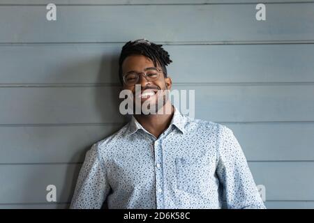 Portrait de l'homme biracial souriant 20s isolé sur fond gris Banque D'Images