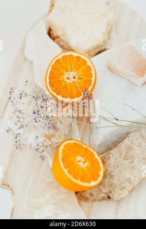 Vue de dessus des moitiés d'oranges fraîches disposées sur du marbre morceaux à fleur délicate Banque D'Images