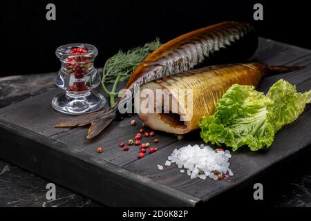 Poisson fumé aux herbes sur une planche de bois. Belle nourriture de maquereau. Banque D'Images