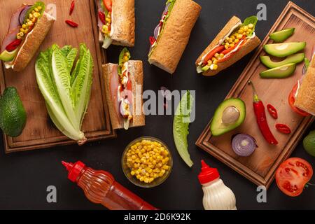 Ensemble d'ingrédients pour les sandwichs au jambon sur une table sombre, vue de dessus. Gros plan Banque D'Images