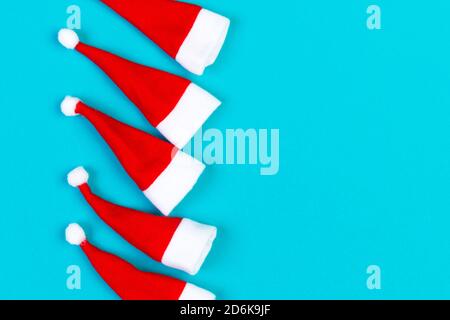 Vue de dessus od rouge élégant Santa hats sur fond coloré. Joyeux Noël concept avec copie espace. Banque D'Images