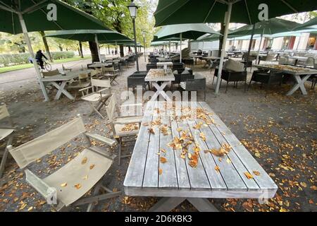 Sujet: Pandémie de coronavirus/conséquences pour la gastronomie. Les feuilles d'automne, les feuilles marron et jaune se trouvent sur les tables. Chaises et tables vides et inoccupées dans la zone extérieure du Tambosi dans la Hofgarten à Munich le 15 octobre 2020. Tables et chaises vides, fermeture due à la pandémie de corona, verrouillage, fermeture, valeur d'incidence. | utilisation dans le monde entier Banque D'Images