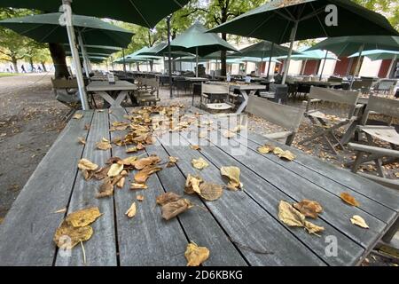 Sujet: Pandémie de coronavirus/conséquences pour la gastronomie. Les feuilles d'automne, les feuilles marron et jaune se trouvent sur les tables. Chaises et tables vides et inoccupées dans la zone extérieure du Tambosi dans la Hofgarten à Munich le 15 octobre 2020. Tables et chaises vides, fermeture due à la pandémie de corona, verrouillage, fermeture, valeur d'incidence. | utilisation dans le monde entier Banque D'Images