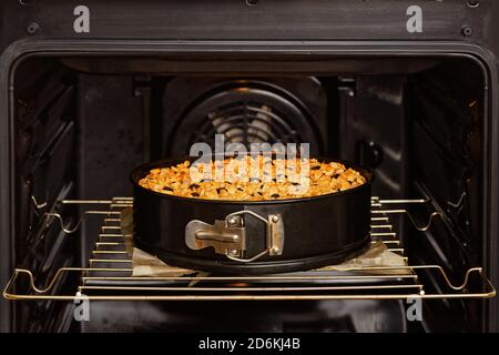 Gâteau maison fraîchement préparé avec des noix et des myrtilles dans le four domestique. Mise au point peu profonde. Banque D'Images