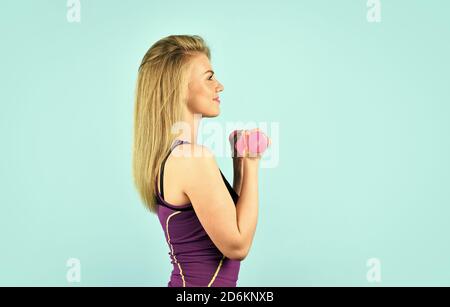 Corps sain. Fille sportive avec corps fort. Concept Sportswoman. S'engager à être en forme. Motivation de l'entraînement. Prenez soin de votre corps. Ne vous arrêtez pas avant de tomber. Jolie femme faisant des exercices avec des haltères. Banque D'Images