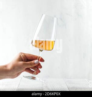Un verre de vin d'orange dans les mains d'une fille. Copier l'espace. Banque D'Images