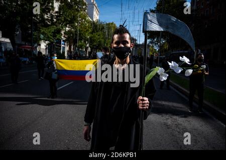 Madrid, Espagne. 18 octobre 2020. Un homme vêtu de noir avec un scythe et des fleurs lors d'une manifestation où les gens de la communauté colombienne de Madrid réclament la paix et la reconnaissance d'une crise humanitaire en Colombie. Credit: Marcos del Mazo/Alay Live News Banque D'Images