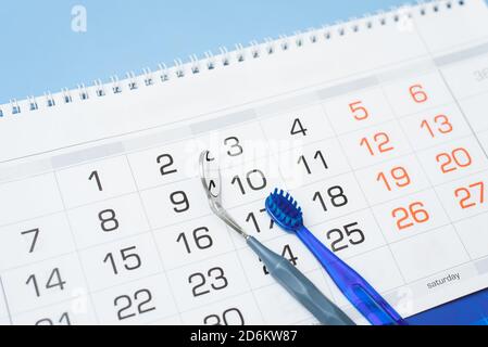 La brosse à dents et l'instrument dentaire sont sur le calendrier. Concept de santé dentaire et de soins dentaires. Banque D'Images