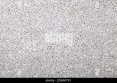 Fond et texture de mousse souple grise avec copeaux ronds. Mousse de polystyrène. Banque D'Images
