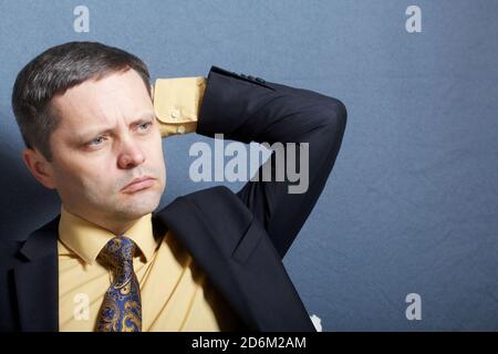 Portrait d'un homme en costume avec cravate. S'assoit à la table avec un aspect pensif. Banque D'Images