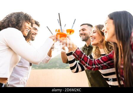 Course mixte Happy Friends groupe toasting avec des lunettes Spritz extérieur Au coucher du soleil - les jeunes s'amusent ensemble à boire un cocktail pour l'apéritif - Banque D'Images