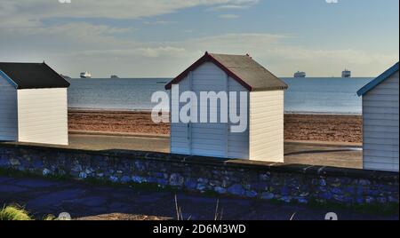 Trois navires de croisière ancrés à Tor Bay pendant la pandémie du coronavirus, vus entre des cabanes de plage sur le front de mer de Goodrington. Banque D'Images