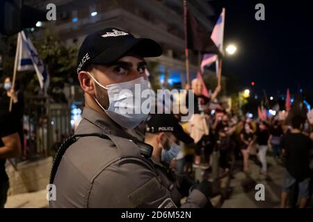 JÉRUSALEM, ISRAËL - 17 OCTOBRE : la police veille à ce que des foules de manifestants se rassemblent lors d'une manifestation devant la résidence officielle du Premier ministre Benjamin Netanyahu, demandant sa démission le 17 octobre 2020 à Jérusalem, en Israël. Les manifestations se sont renouvelées à Jérusalem à la suite de la fin des mesures d'urgence qui ont limité les manifestations en cours contre le premier ministre en raison de son inculpation pour corruption et de la gestion de la pandémie COVID-19. Banque D'Images