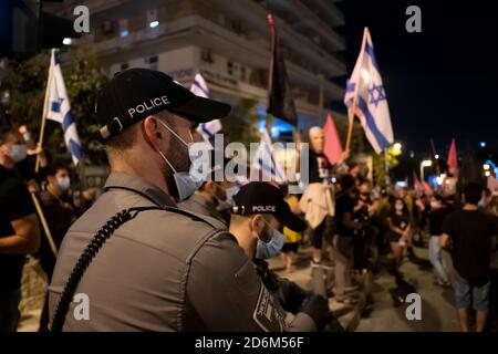 JÉRUSALEM, ISRAËL - 17 OCTOBRE : la police veille à ce que des foules de manifestants se rassemblent lors d'une manifestation devant la résidence officielle du Premier ministre Benjamin Netanyahu, demandant sa démission le 17 octobre 2020 à Jérusalem, en Israël. Les manifestations se sont renouvelées à Jérusalem à la suite de la fin des mesures d'urgence qui ont limité les manifestations en cours contre le premier ministre en raison de son inculpation pour corruption et de la gestion de la pandémie COVID-19. Banque D'Images