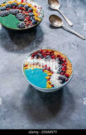 Bols à smoothie en spiruline bleu et vert avec fruits et graines de lin - idée de petit déjeuner de superalimentation saine. Vue grand angle Banque D'Images