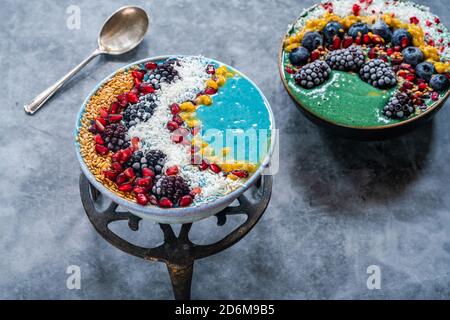 Bols à smoothie en spiruline bleu et vert avec fruits et graines de lin - idée de petit déjeuner de superalimentation saine. Vue grand angle Banque D'Images