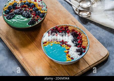 Bols à smoothie en spiruline bleu et vert avec fruits et graines de lin - idée de petit déjeuner de superalimentation saine. Vue grand angle Banque D'Images