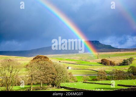 Arc-en-ciel sur Yorkshire Dales campagne terres agricoles avec la montagne de Pen-y-gand sur la Pennine Way au loin Banque D'Images