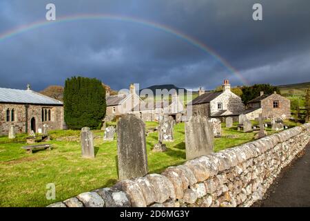 Arc-en-ciel au-dessus de l'église du village de St Oswald dans le Yorkshire village de Horton à Ribblesdale avec la montagne de Pen-y-gand sur la Pennine Way Banque D'Images