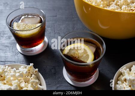 Bol avec pop-corn et verres de cola glacé sur fond bleu. Perspective Banque D'Images