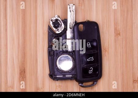 Télécommande cassée ou endommagée sur le porte-clés en bois arrière-plan de tout service de verrouillage de véhicule. Banque D'Images