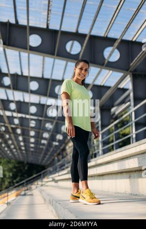 Jeune femme en tenue de sport souriant et regardant l'appareil photo Banque D'Images