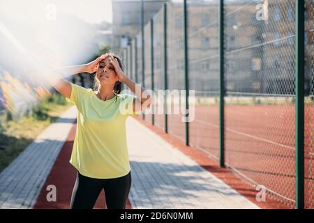 Belle femme de fitness se sentant fatiguée après la course du matin Banque D'Images