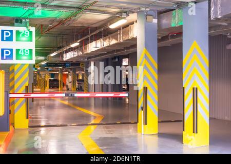 Barrière à l'entrée du numéro de luminescent - panneau de places de parking gratuites sous le bâtiment de l'appartement Banque D'Images