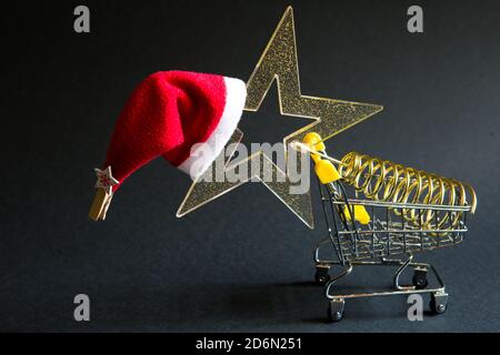 Panier avec une étoile dorée transparente avec des paillettes en forme d'arbre de Noël sur fond noir. Vendredi noir, acheter des cadeaux pour le nouveau Banque D'Images