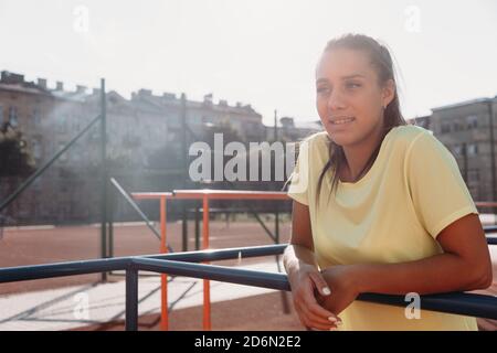 Une jolie brunette se tenant au stade après l'entraînement Banque D'Images