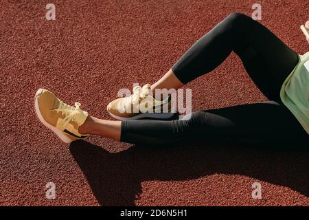 Gros plan des jambes des femmes se détendant sur la cour rouge Banque D'Images