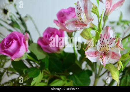beau bouquet de fleurs mélangées dans un vase sur une table blanche. le travail du fleuriste dans un fleuriste. un mélange lumineux d'alstroemeria, chrysanthèmes Banque D'Images