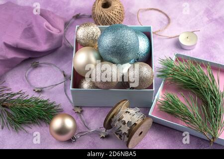 Boules de Noël bleues et dorées dans une boîte sur fond de bois. Banque D'Images