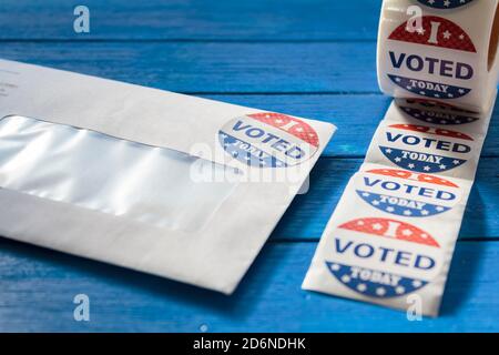 Enveloppe avec bulletins de vote envoyés par la poste pour les absents Votez à l'élection présidentielle et j'ai voté aujourd'hui autocollants sur table en bois bleu Banque D'Images