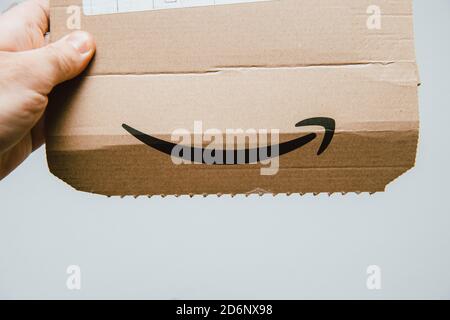 Paris, France - 14 mars 2018: POV Man main tenant Amazon Prime carton paquet montrant le logotype insignia - isolé sur blanc Banque D'Images