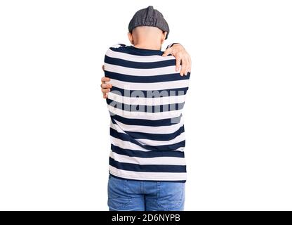 Jeune homme beau portant le masque cambrioleur se embrassant heureux et positif de l'arrière-plan. Amour de soi et soins de soi Banque D'Images