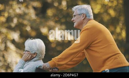 Vieux couple ayant un romantique jour d'automne dans la forêt. Un arbre enterre et souriant. Photo de haute qualité Banque D'Images